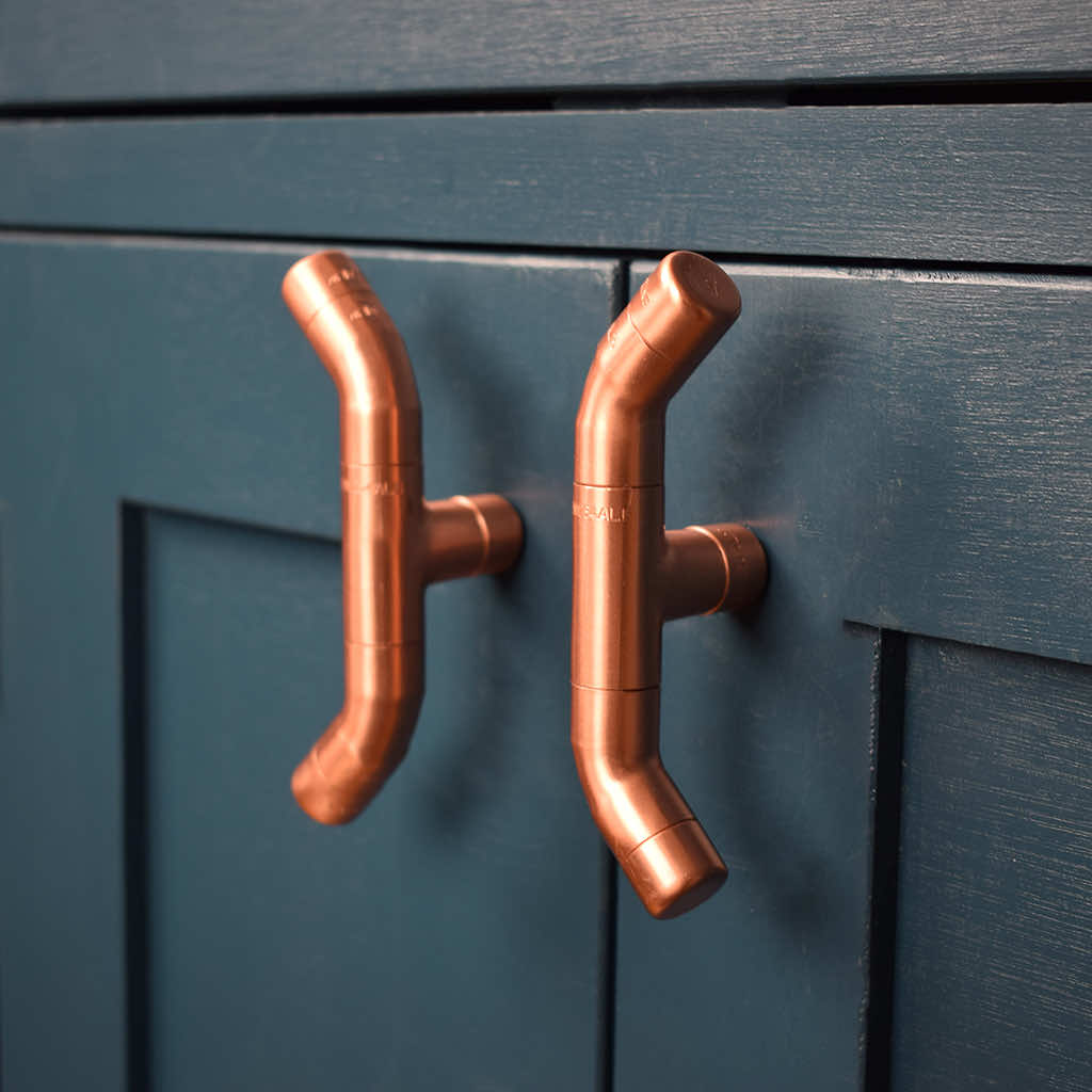 Curved Copper Handle on Blue Cabinet Angled