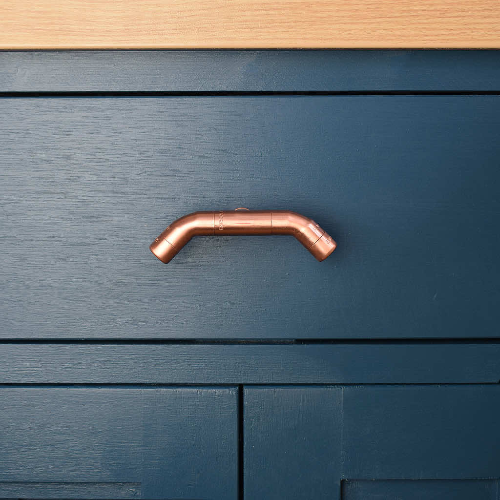 Curved Copper Handle on Blue Cabinet Front Shot