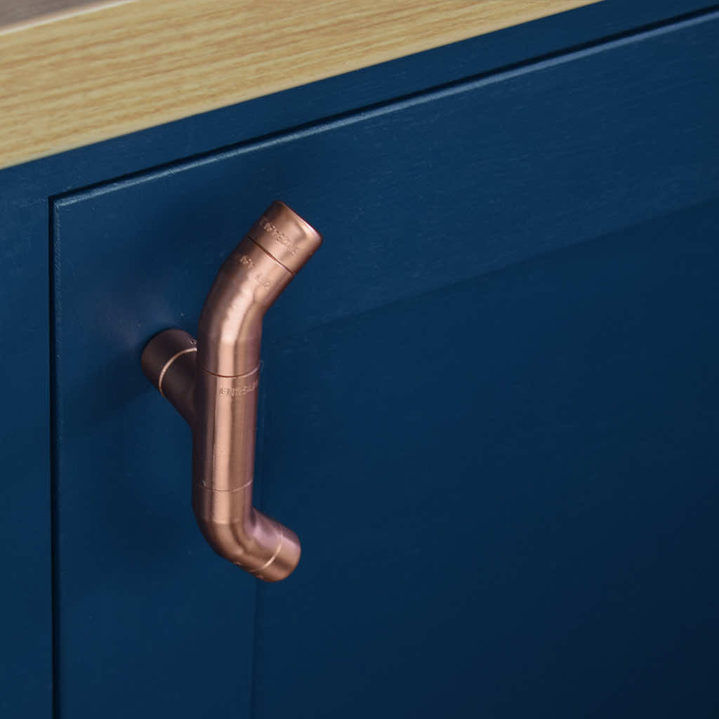 Curved Copper Handle on Blue Cabinet