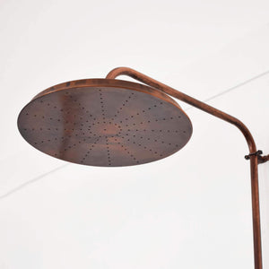 large copper shower head with a rustic copper patina