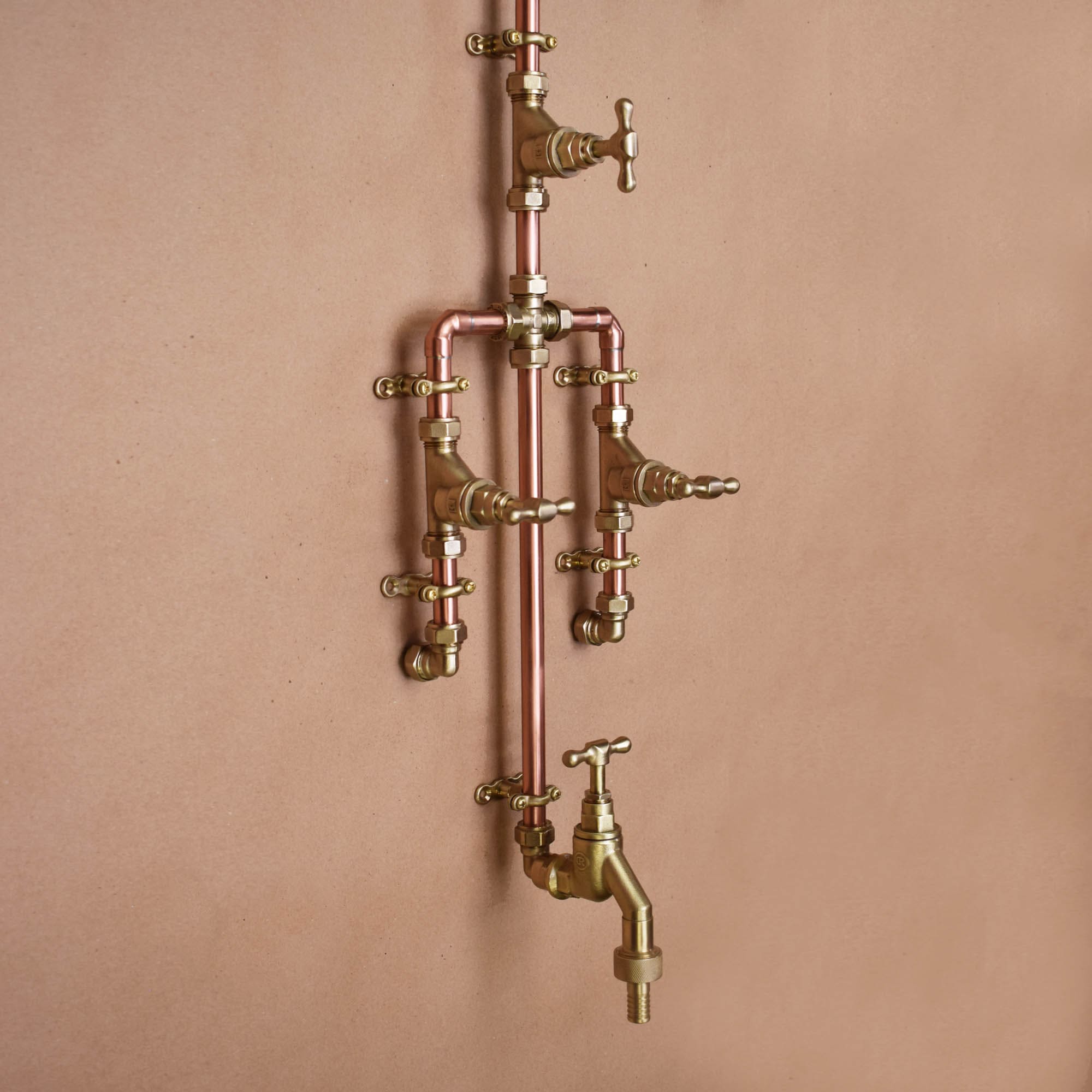 Vintage-inspired copper outdoor shower with a curved design on a plastered wall