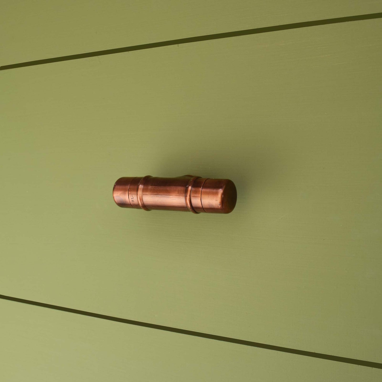 Antique Copper Knob T-shaped on green cabinet drawers