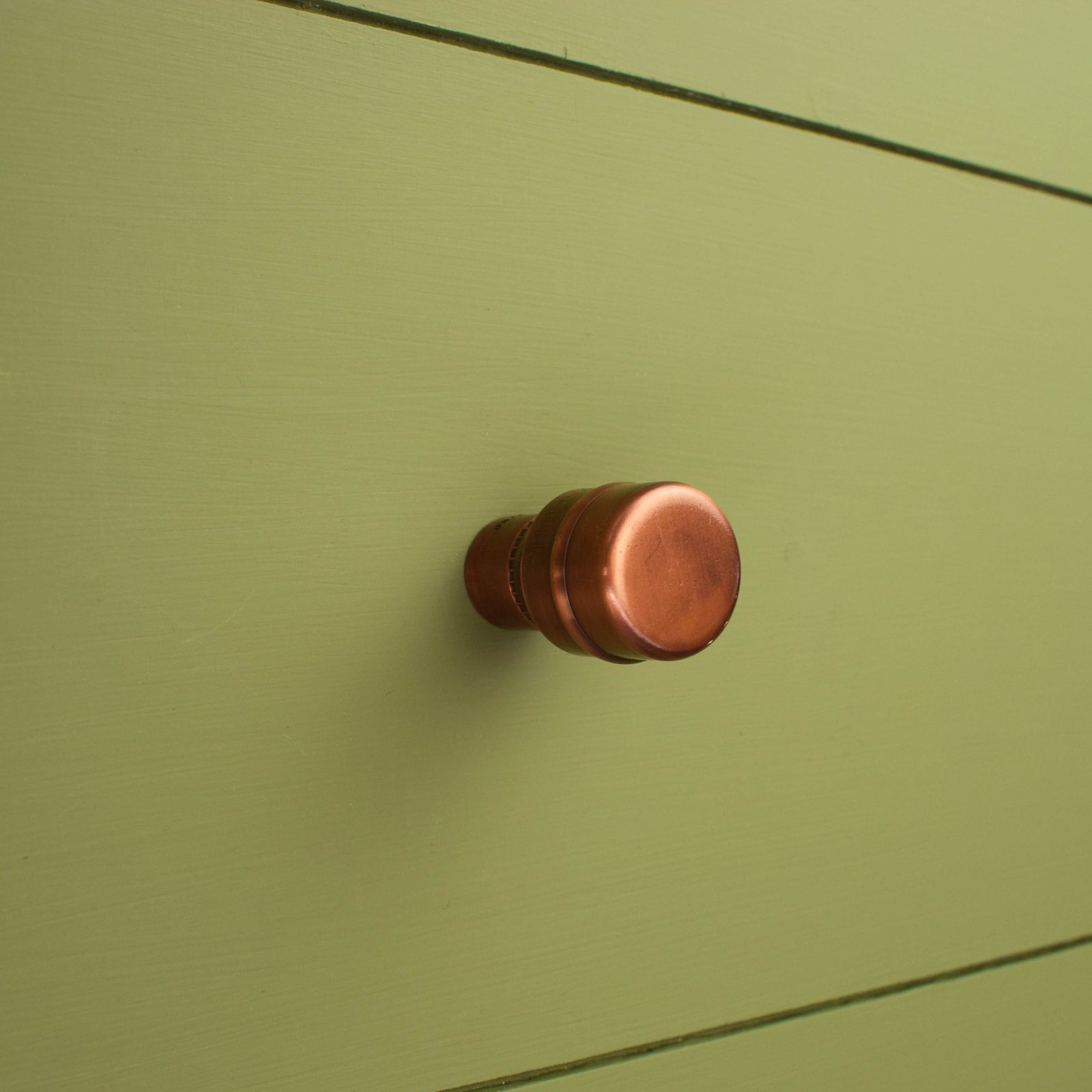 The Alder aged copper knob on green shaker cabinet drawer