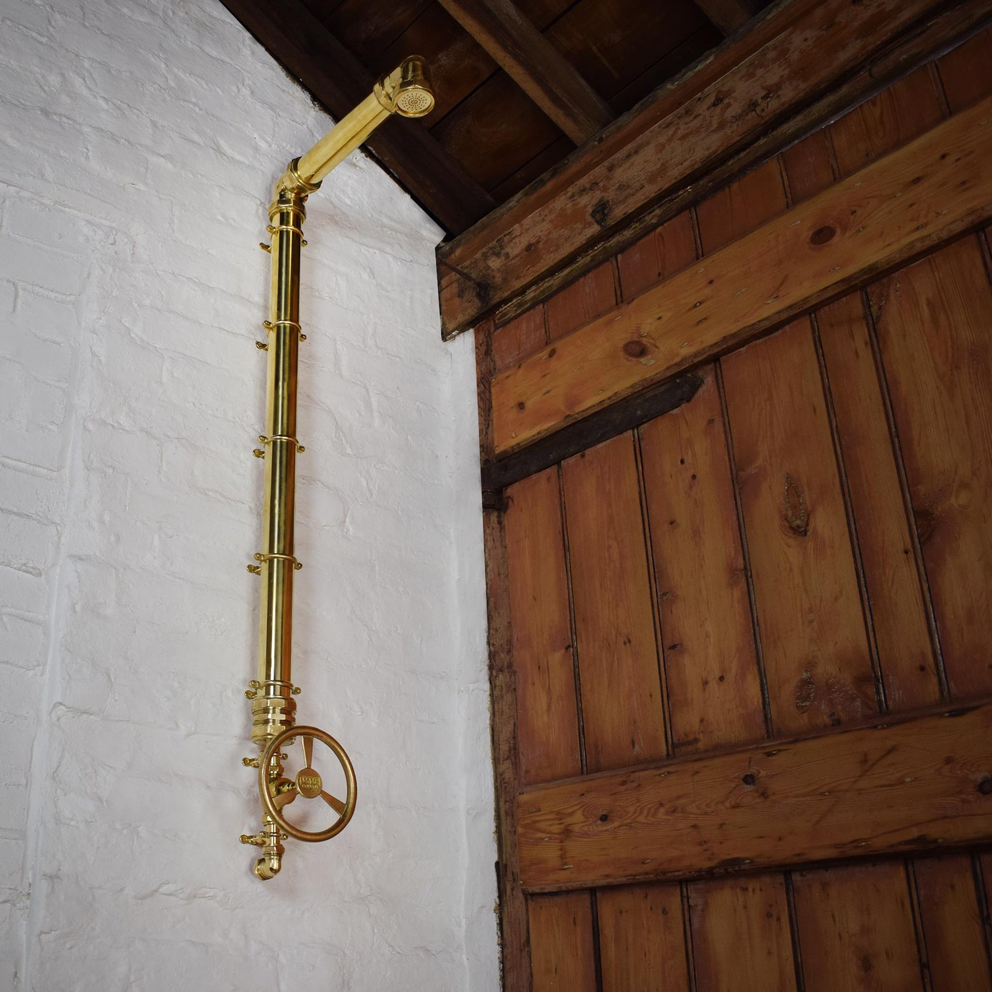 large brass shower with industrial brass tap turns